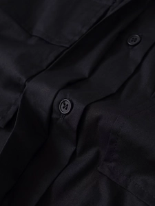 Close-up of high-quality black cotton fabric with a classic four-hole button and stitching