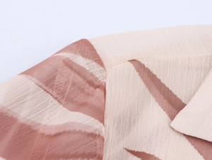 Macro detail of high-quality chiffon fabric with brown botanical prints on shoulder seam