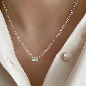 Detail of 925 sterling silver paperclip chain necklace with emerald cut white zircon