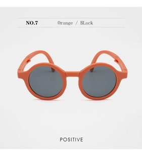Front view of orange round frame children sunglasses with black lenses and matte texture