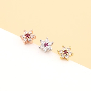 Vue détaillée des boucles d'oreilles fleurs en or rose, argent et or avec gemmes roses