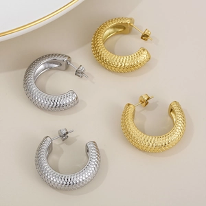 Detail of 18K gold and silver chunky C-shaped earrings with unique fish scale texture