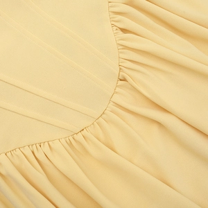 Macro shot of the pleated texture and refined stitching on a yellow strapless dress