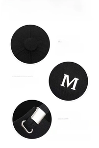 Detail view of canvas baseball cap with metal M logo and adjustable back buckle
