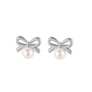 Vue macro de boucles d'oreilles nœud en métal argenté poli avec d'élégantes perles blanches