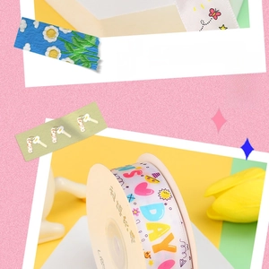 Close-up of decorative white ribbon with colorful heart and sun patterns on a card spool