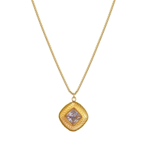 Macro shot of gold square zircon pendant with a detailed textured border and box chain
