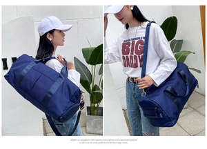Deep blue fitness travel bag shown in shoulder and crossbody styles by a female model