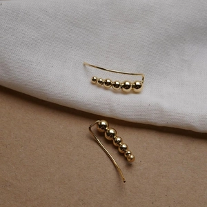 Minimalist S925 silver stud earrings with graduated gold beads in a linear design
