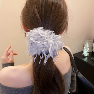 Gros plan d'un chouchou en plumes lavande duveteuses pour une coiffure élégante