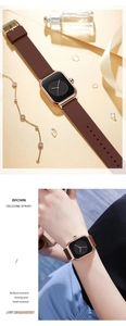 Detail view of a square quartz watch featuring a brown silicone strap on a wrist