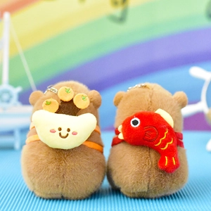 Detailed view of cute capybara plush keychains with fruit and fish accessories