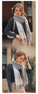 Detailed knit texture of a soft plaid tassel scarf in grey, beige, and light blue tones