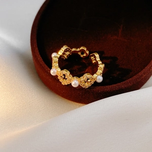 Vue détaillée de la bague florale plaquée or 18k avec perles et zircon dans un écrin