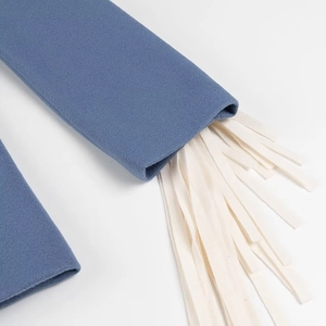Close-up detail of blue wool blazer cuff featuring elegant white flat fringe trim