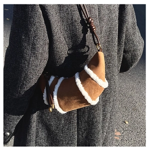 Detail der Wildleder-Hörntasche mit weißem Plüschbesatz und geflochtenem Riemen