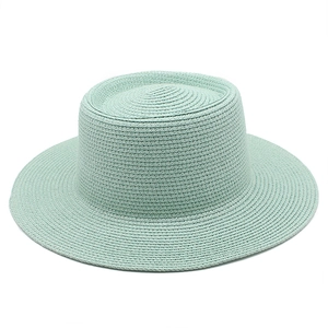 Detailed weave of mint green wide-brim straw boater hat with a flat top and uniform edges
