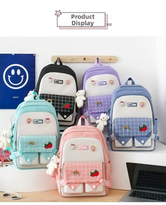 Five school backpacks in pastel colors featuring cute plush bear charms and pins