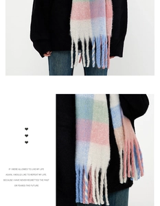 Detail of colorful plaid scarf showing thick fuzzy texture and long tassel fringe edges