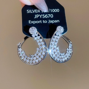 Vue macro de boucles d'oreilles gouttes en zircons sur carte de présentation