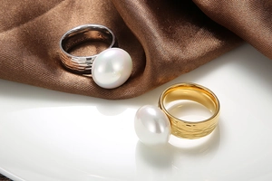 Detail of gold and silver hammered stainless steel rings with large white pearls