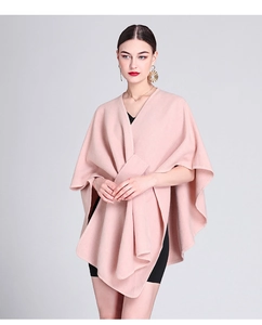 Detail shot of a soft pink knitted poncho cape over a black dress for women