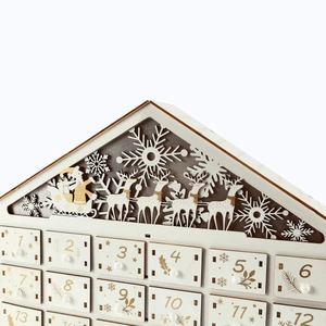 Close-up of wooden advent calendar featuring laser-cut reindeer and gold numbered drawers