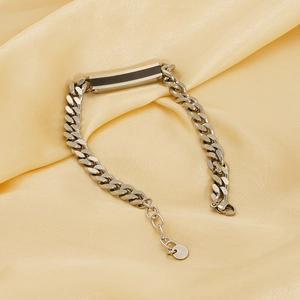 Mens stainless steel curb chain bracelet with black bar accent on silk background