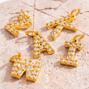 Luxury 18K gold-plated initial pendants with sparkling white zircons on stone surface