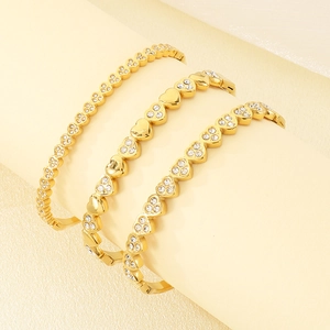 Macro shot of gold heart bangles with white zirconia stones on a professional display