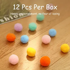 Set di 12 palline di peluche colorate per gatti sparse su un pavimento in legno naturale