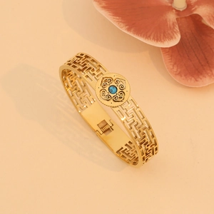 Retro hollowed-out stainless steel gold bangle featuring an inlaid turquoise gemstone