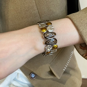 Detail view of a vintage stretch bracelet with amber patterns and silver metal accents