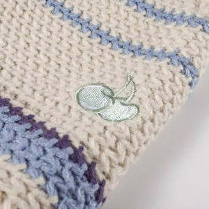 Off-white cable knit hat with blue purple stripes and green cherry embroidery detail
