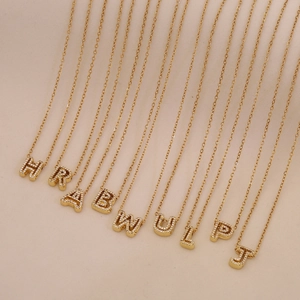 Gold plated initial pendant necklaces with clear cubic zirconia in a neat hanging display