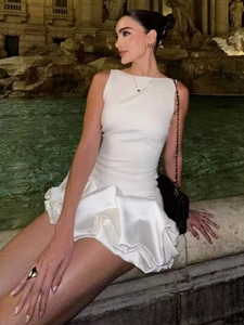Élégante mini-robe en satin blanc sans manches avec ourlet à volants sur fond de ville