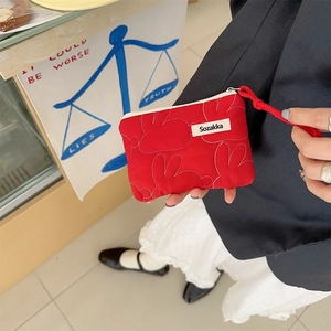 Detail of red floral quilted coin purse with cute white rabbit embroidery and zipper