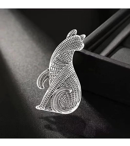Detailed close-up of a silver fox brooch with intricate tribal mandala style engravings
