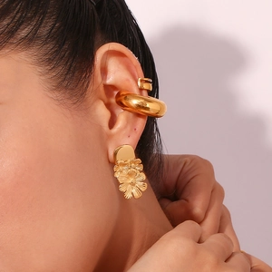 Detail of 18K gold plated floral stud earring and thick ear cuff on model
