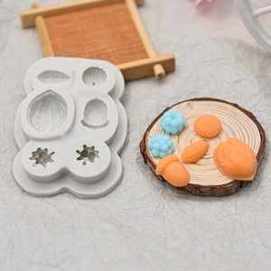 Silicone mold for hazelnut and pine cone shapes with orange and blue fondant cakes