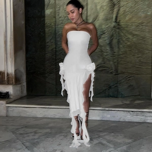 Détail de la robe bustier blanche avec bords à volants et fente latérale élégante sur la jupe