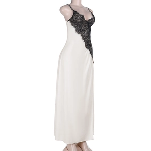 Detail of white satin dress featuring intricate black lace trim on the V-neckline
