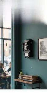 Detail of vintage wall-mounted telephone model with distressed finish on a textured wall