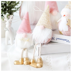 Close-up of pink velvet gnome and snowman Christmas hanging ornaments with golden boots
