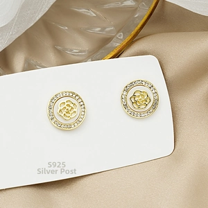 Detail of S925 silver needle rose flower earrings with pavé crystals in gold plating
