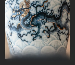 Macro shot of blue and white dragon porcelain tea cup with gold inlay details