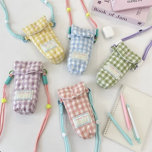 Quilted crossbody phone bags in pastel colors with woven straps and checkered patterns