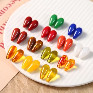 Colorful resin teardrop beads for DIY jewelry making displayed on a white textured tray