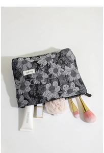 Vue détaillée de la trousse à maquillage jacquard fleurie avec cosmétiques et logo H&R BAG