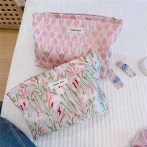 Detail of floral and heart jacquard texture on spacious makeup bags with simple wish label